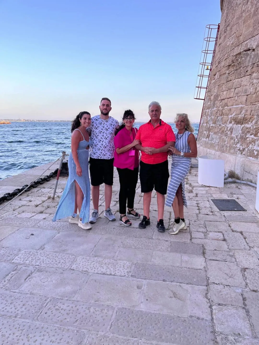 Margherita and her clients (a family) standing next the Castello Aragonese near the sea in Taranto.